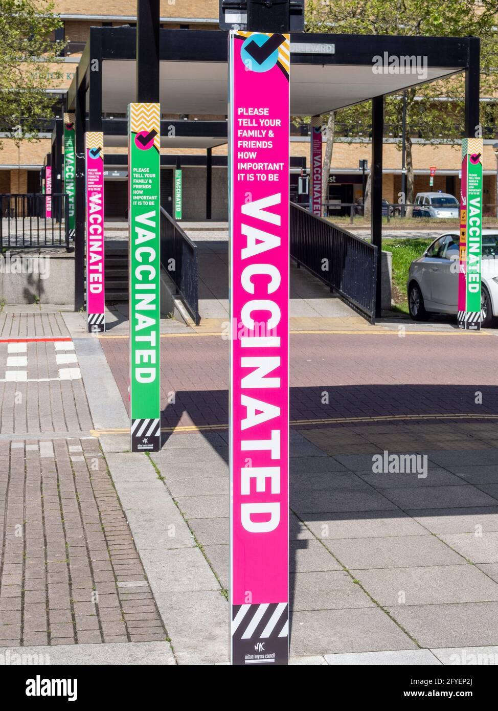 Carteles durante la pandemia que aconsejan a las personas la importancia de vacunarse contra Covid-19, en el centro de Milton Keynes, Reino Unido Foto de stock