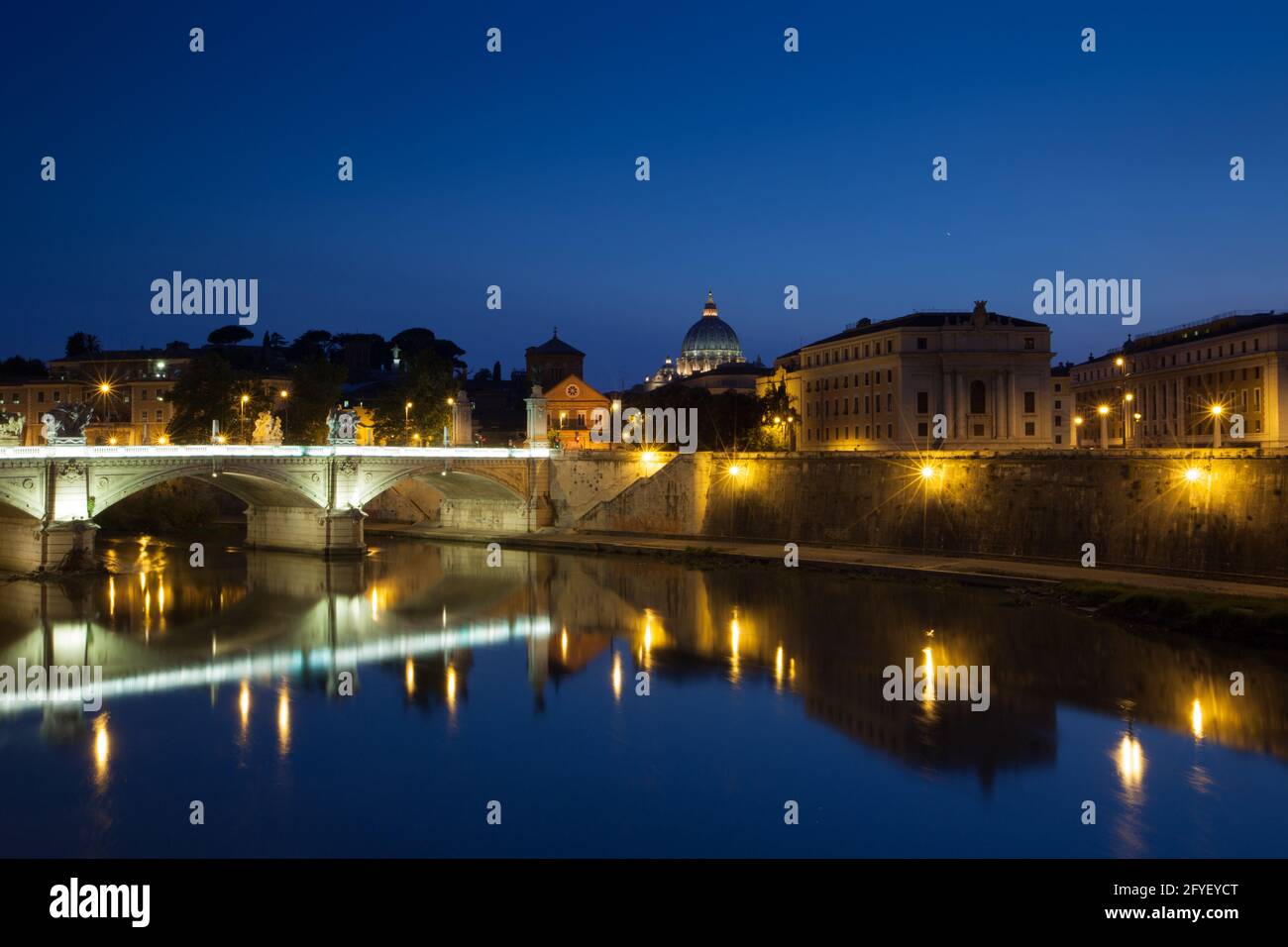 Roma por la noche con el Ponte Vittorio Emmanuel II sobre el río Tíber y la cúpula de la Basílica de San Pedro a la derecha. Roma, Italia Foto de stock