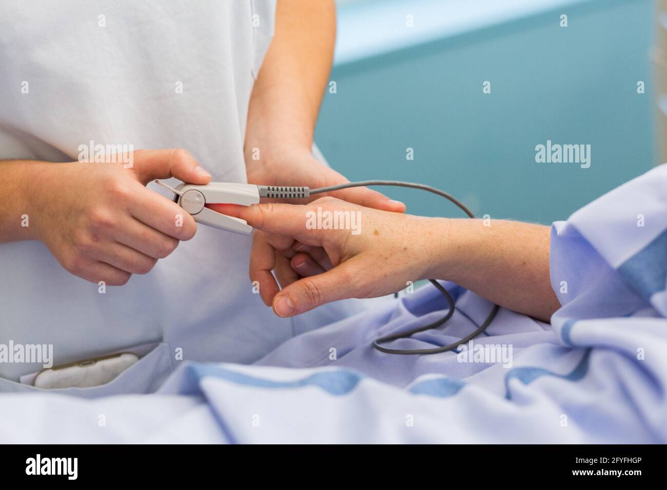 Enfermera con un paciente hospitalizado. Limoges hospital, Francia, determinación de la saturación de oxígeno-hemoglobina de la sangre con un oxímetro de pulso. Foto de stock