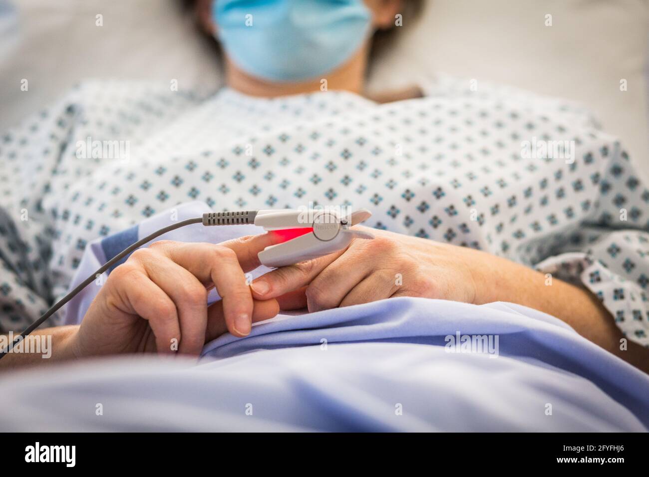Enfermera con un paciente hospitalizado. Limoges hospital, Francia, determinación de la saturación de oxígeno-hemoglobina de la sangre con un oxímetro de pulso. Foto de stock