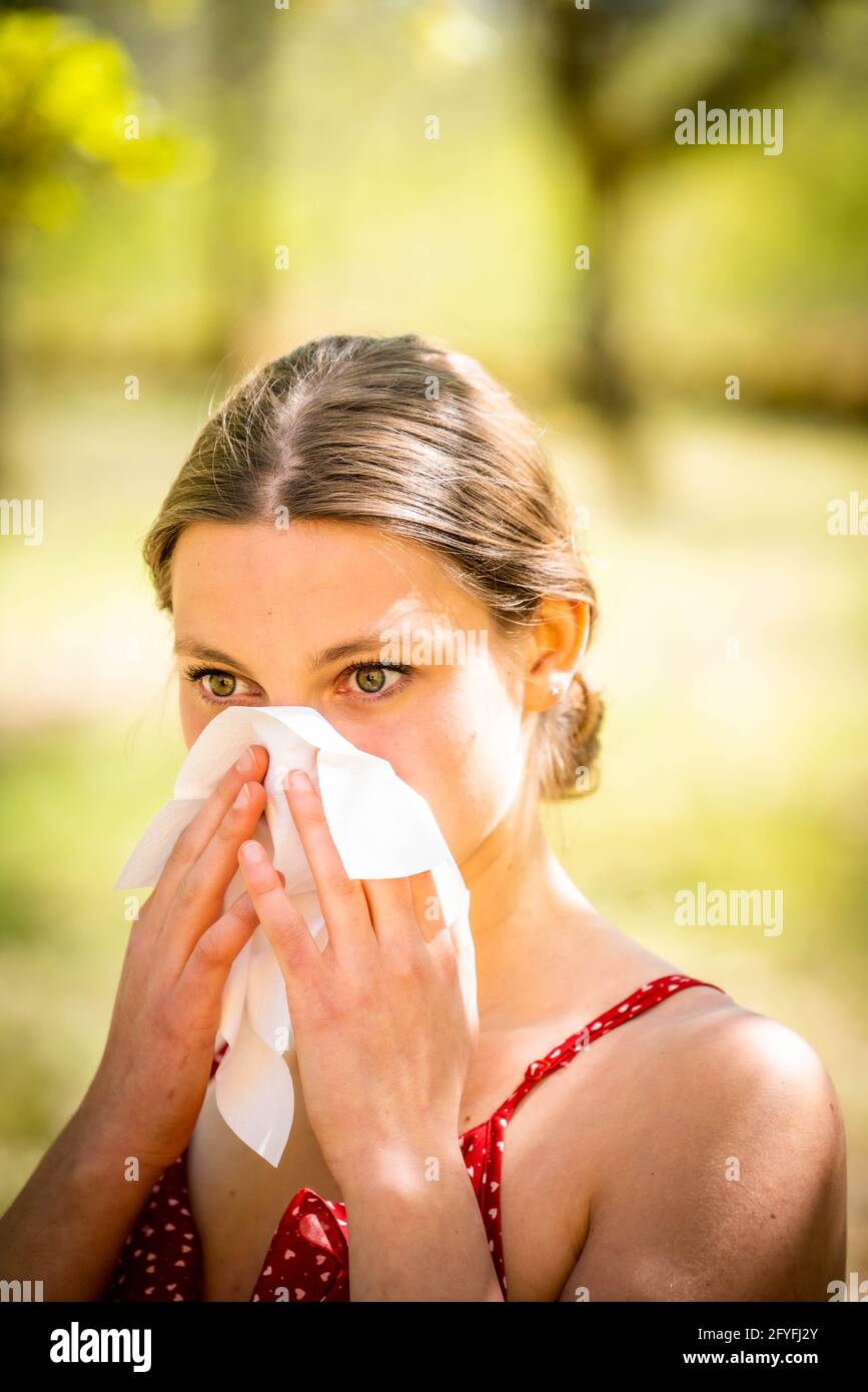 Mujer con fiebre del heno sonarse la nariz. Foto de stock