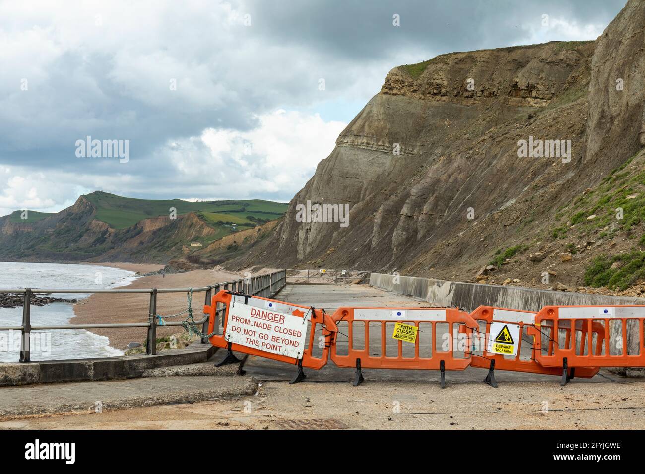 Señales de advertencia que alertan de que el camino costero del paseo marítimo está cerrado debido al peligro de que el público caiga roca. West Bay, Dorset, Inglaterra, Reino Unido Foto de stock