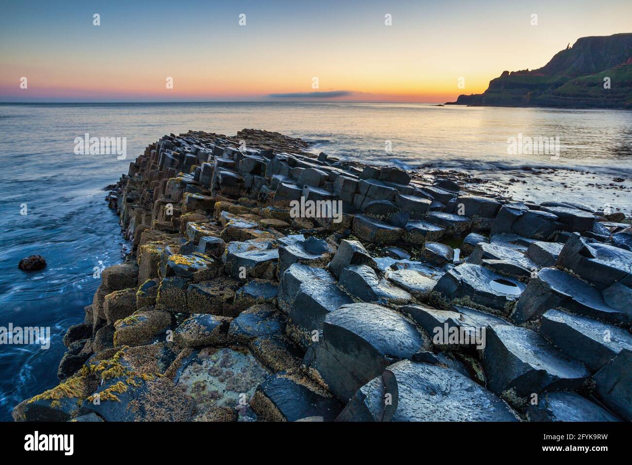 Puesta de sol en la calzada del Gigante en el Condado de Antrim en la costa noreste de Irlanda del Norte. Foto de stock