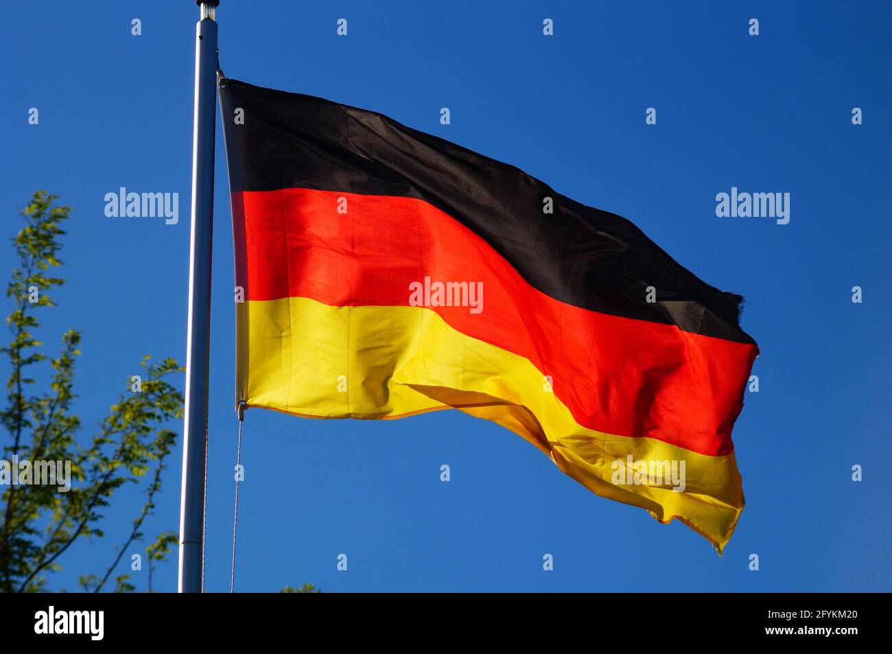 La bandera alemana vuela a la luz de la noche. Foto de stock