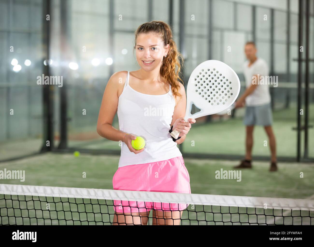 Mujer en pantalones cortos jugando tenis de pádel en la cancha Fotografía  de stock - Alamy