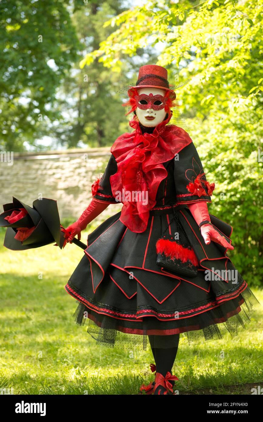Tradicionalmente vestido Venecia carnival persona - mujer en rojo y negro  carnaval traje veneciano Fotografía de stock - Alamy