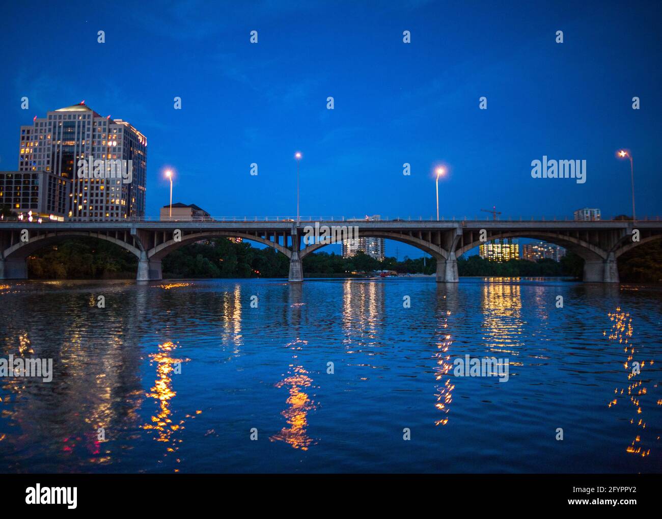 Horizonte de la ciudad de Austin por la noche con el puente de congresos South Congress Bridge desde el río Colorado. Austin, Texas, Estados Unidos Foto de stock