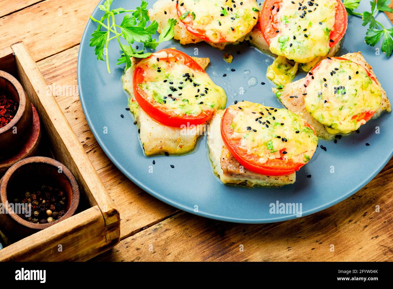 Pescado al horno con queso y tomate. Pangasius asado sobre mesa de madera  Fotografía de stock - Alamy