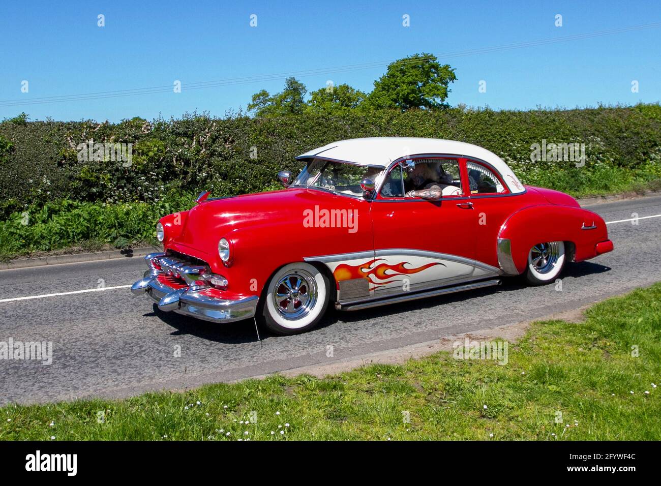 1949 años cuarenta rojo personalizado Chevrolet American Chevy 3540cc. Tráfico, vehículos en movimiento, coches, ee.uu. Vehículo de conducción, carreteras del Reino Unido, motores, Motorización, red de carreteras, en ruta a Capesthorne Hall CLASSIC CAR SHOW de mayo, Cheshire, Reino Unido Foto de stock