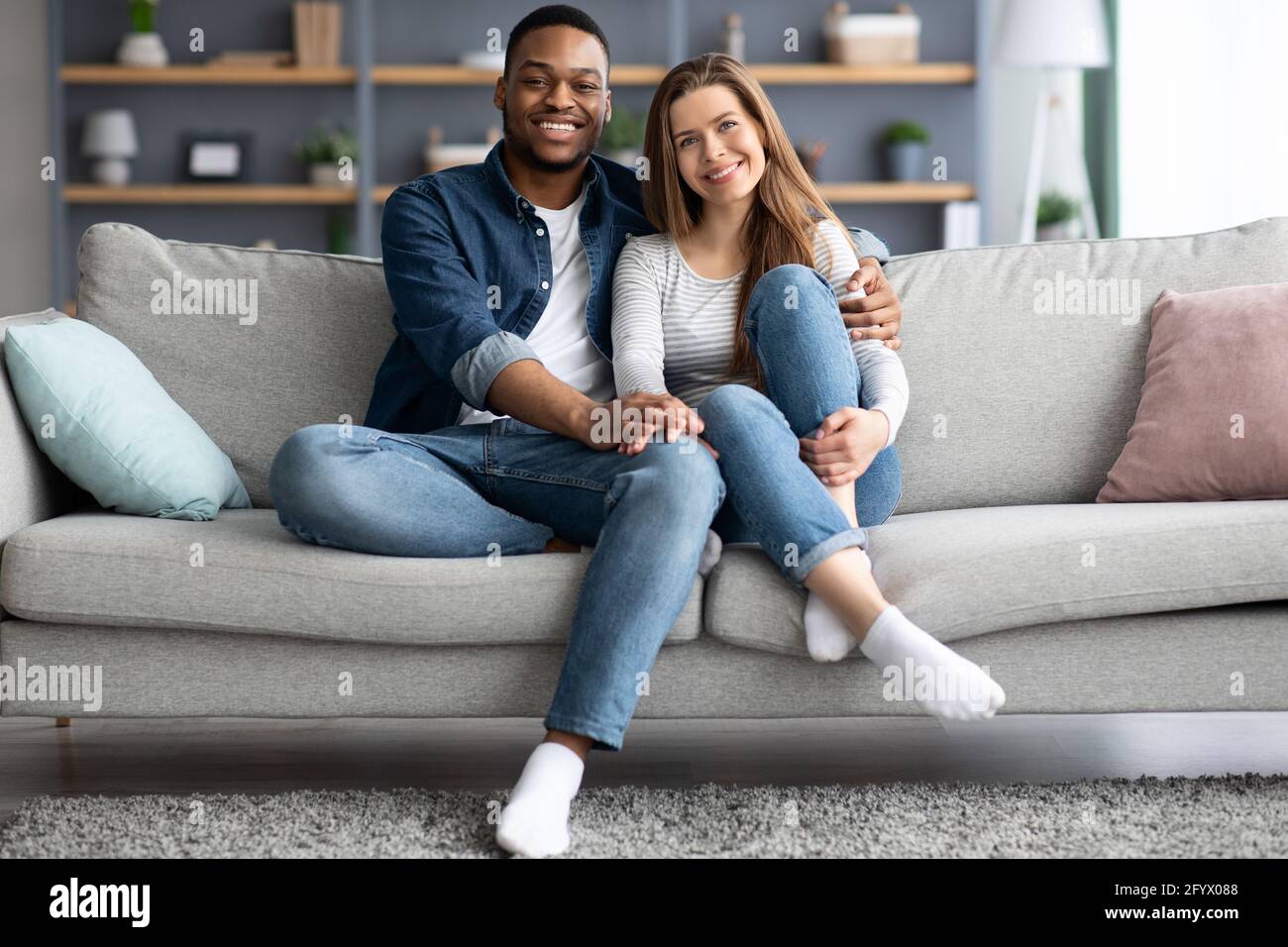Interracial family sitting on couch fotografías e imágenes de alta  resolución - Alamy