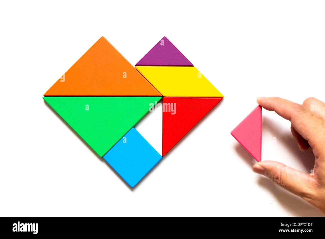 Puzzle de tangram de madera de color en forma de corazón esperar a cumplir  sobre fondo blanco Fotografía de stock - Alamy