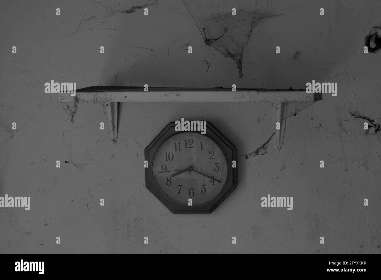 Se detuvo el reloj y la pared con la tela de araña en la antigua casa  abandonada Fotografía de stock - Alamy