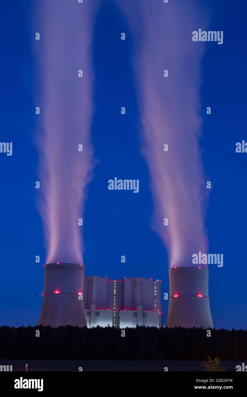 Torres de refrigeración de una central eléctrica alimentada por lignito por la noche Foto de stock