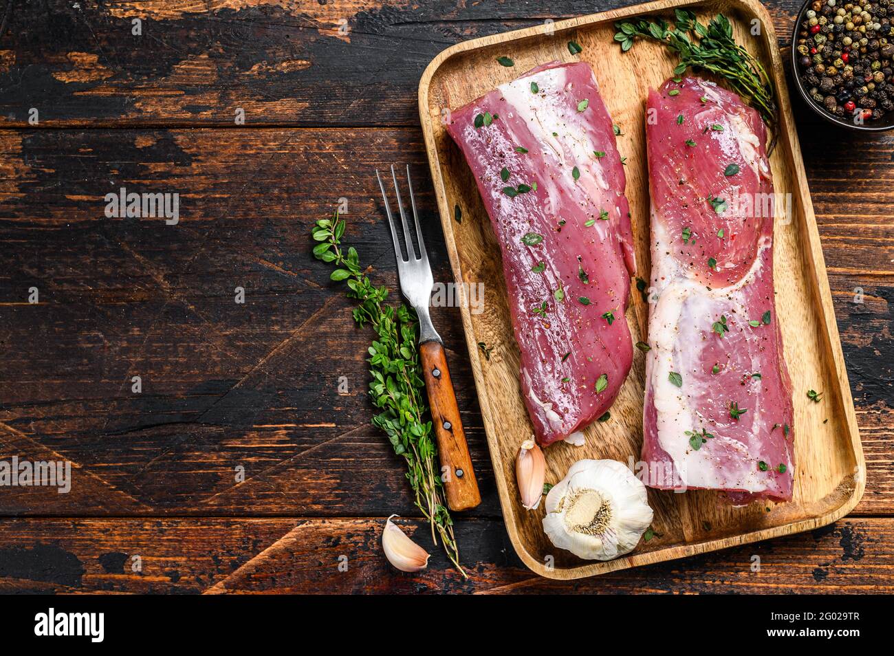 Filete de carne de lomo de cerdo marinado con tomillo. Fondo de madera  oscura. Vista superior. Espacio de copia Fotografía de stock - Alamy