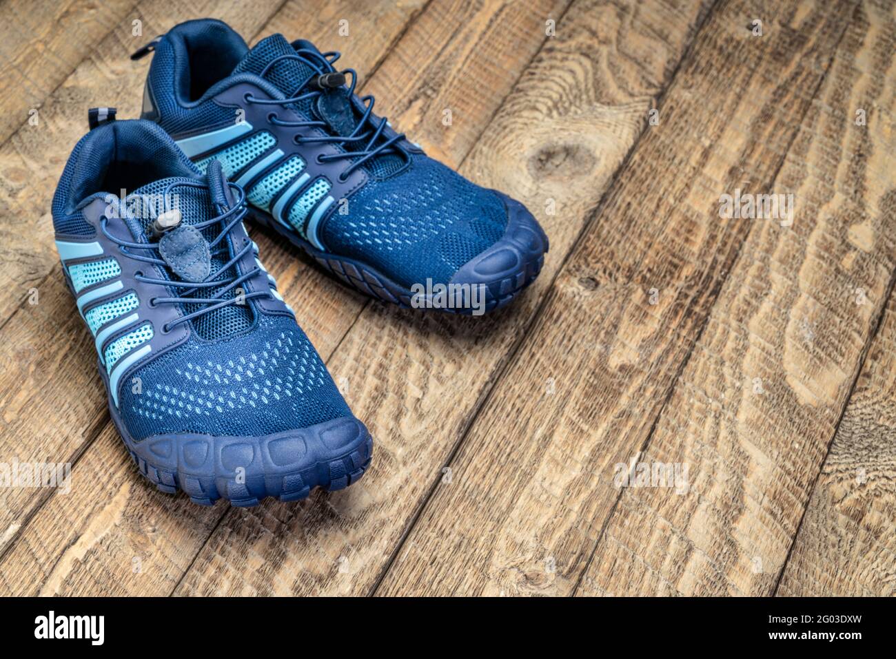 zapatillas de running y entrenamiento cruzado descalzo sobre un fondo rústico de madera Foto de stock