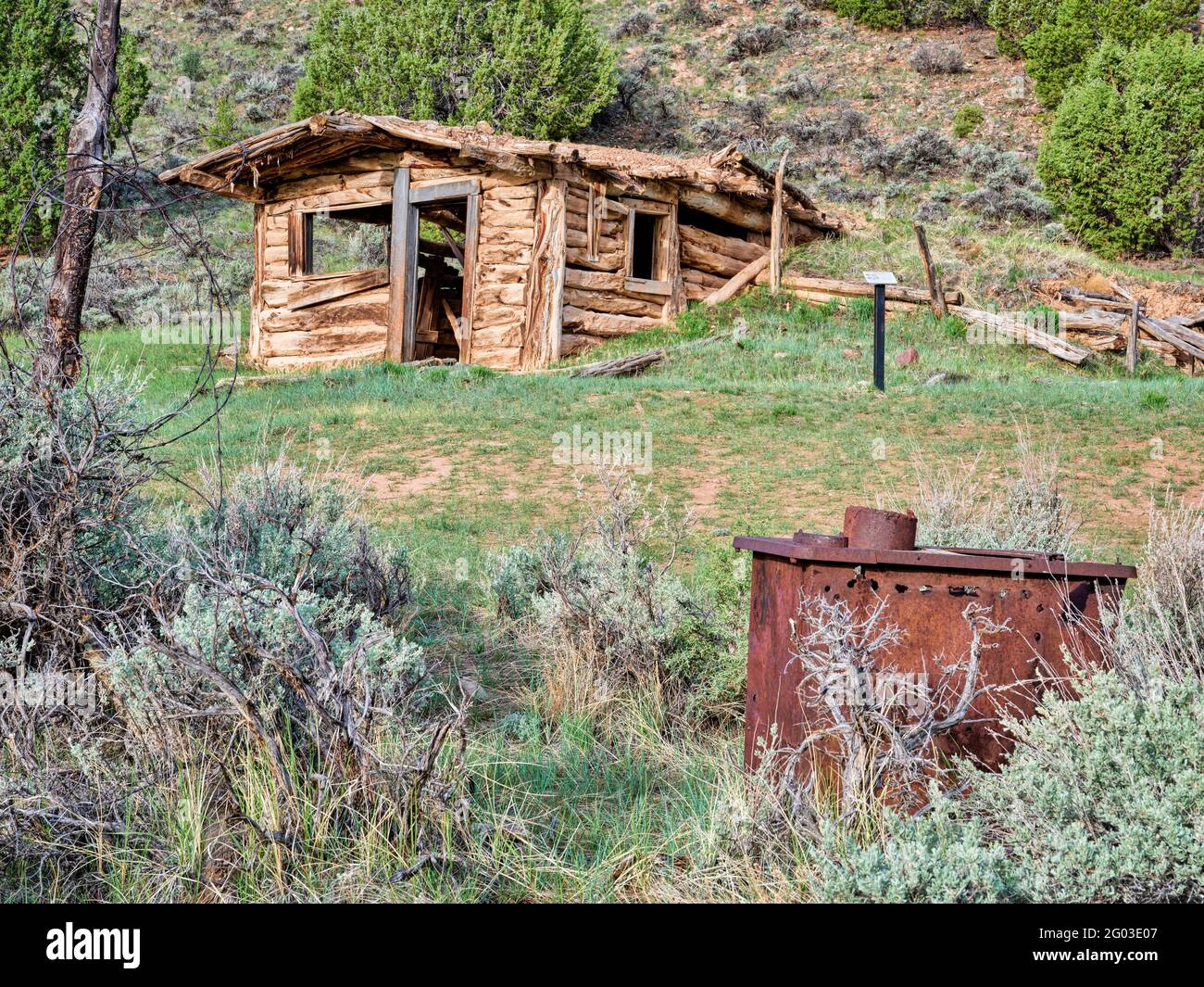 Horno oxidado y una pequeña y antigua cabaña de madera situada en una