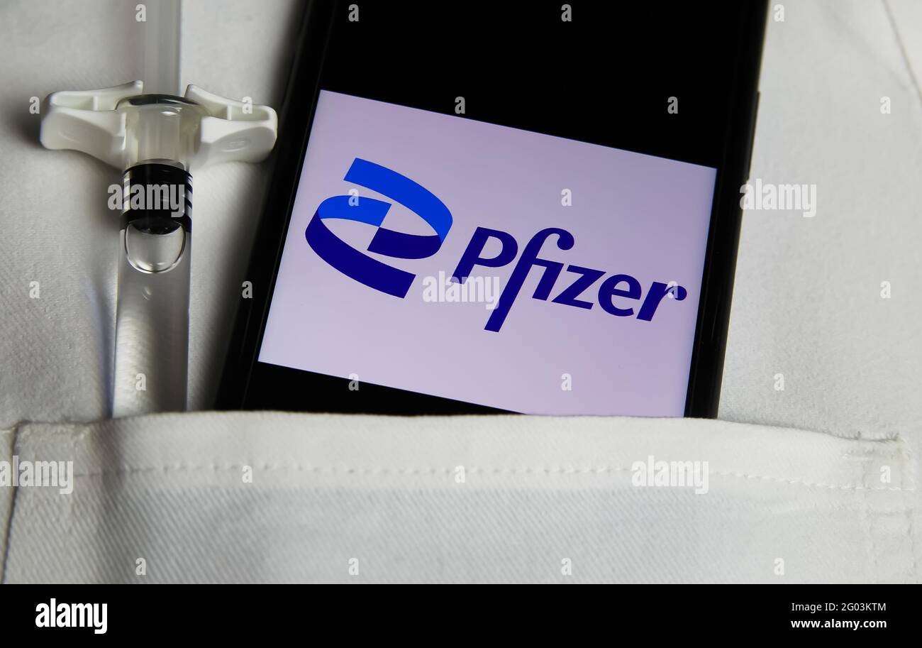 Viersen, Alemania - mayo de 9. 2021: Primer plano de la pantalla del teléfono móvil con logotipo de la empresa farmacéutica Pfizer en el bolsillo de la bata blanca de los médicos Foto de stock
