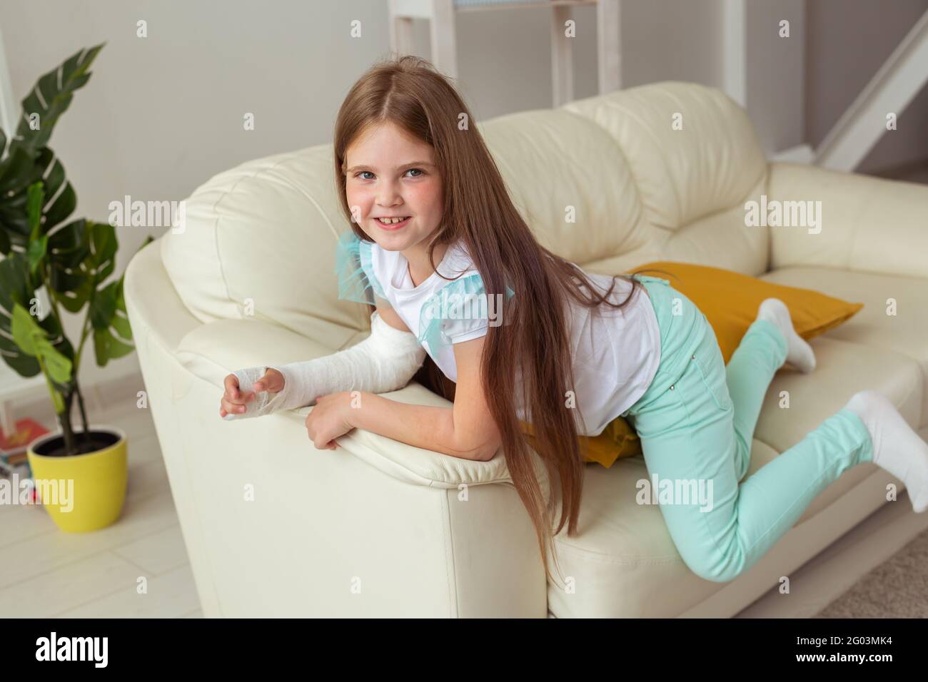 Niño con un yeso en una muñeca o brazo roto sonriendo y divirtiéndose en un  sofá. Actitud positiva, recuperación y concepto de niño Fotografía de stock  - Alamy