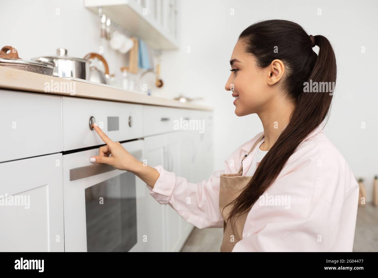 Mujer que usa cocina de cocina en la cocina Foto de stock