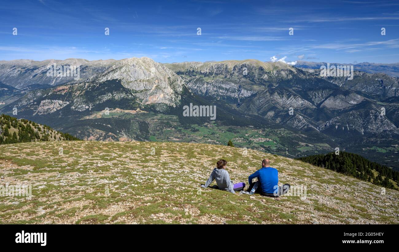 Excursionistas en la cumbre de la Gallina Pelada, el punto más alto de Serra d'Ensija, mirando hacia las caras sur de Pedraforca y Cadí (Berguedà, Cataluña) Foto de stock
