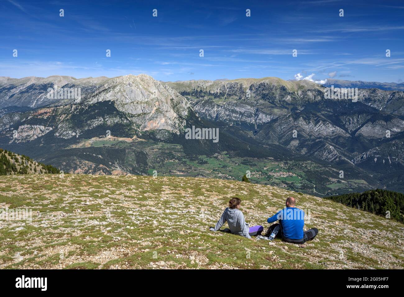 Excursionistas en la cumbre de la Gallina Pelada, el punto más alto de Serra d'Ensija, mirando hacia las caras sur de Pedraforca y Cadí (Berguedà, Cataluña) Foto de stock