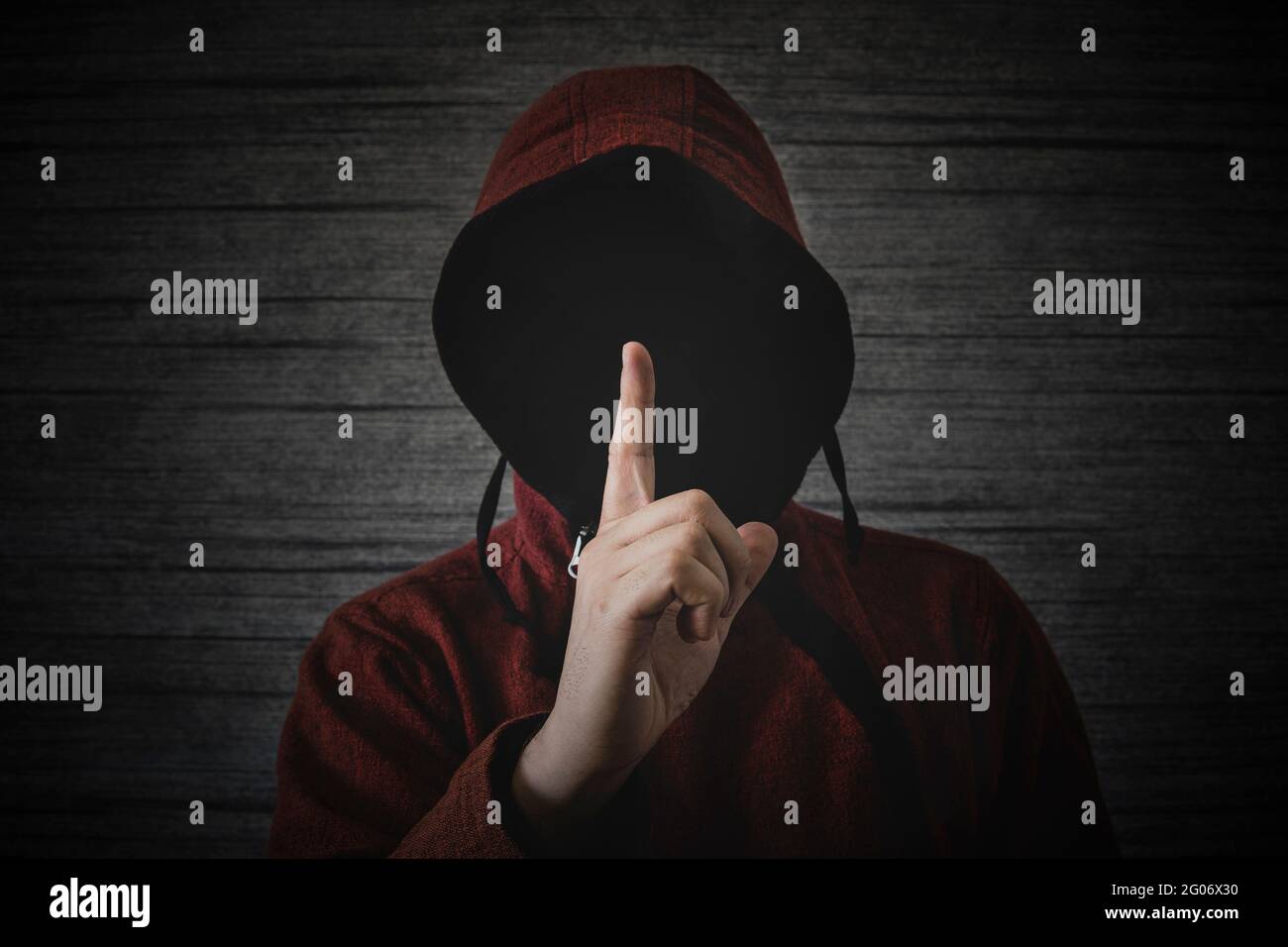 una persona desconocida sin una cara en una capucha muestra un gesto del  dedo que significa ciudades. El concepto de anonimato y secreto en la red  Fotografía de stock - Alamy