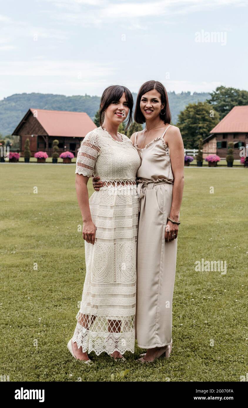 Retrato de dos mujeres hermosas en vestidos con estilo de pie en el césped  Fotografía de stock - Alamy