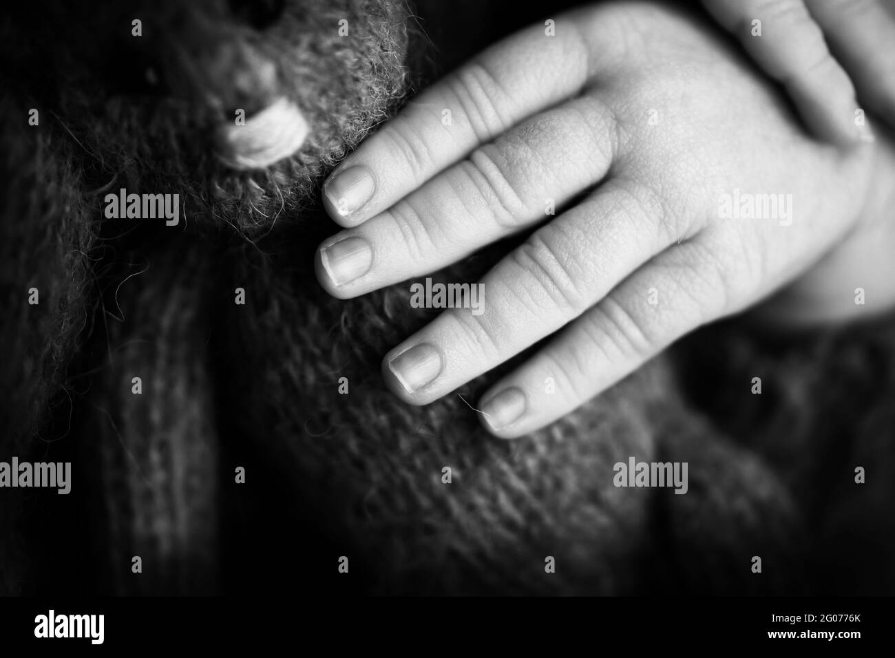 La mano del niño, los dedos se acercan. Manos del bebé recién nacido, concepto de infancia feliz, salud, FIV, higiene. Foto en blanco y negro. Foto de stock