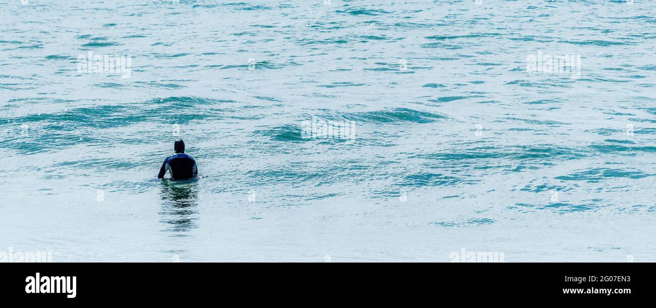 Imagen panorámica de un surfista en el mar esperando una ola. Foto de stock