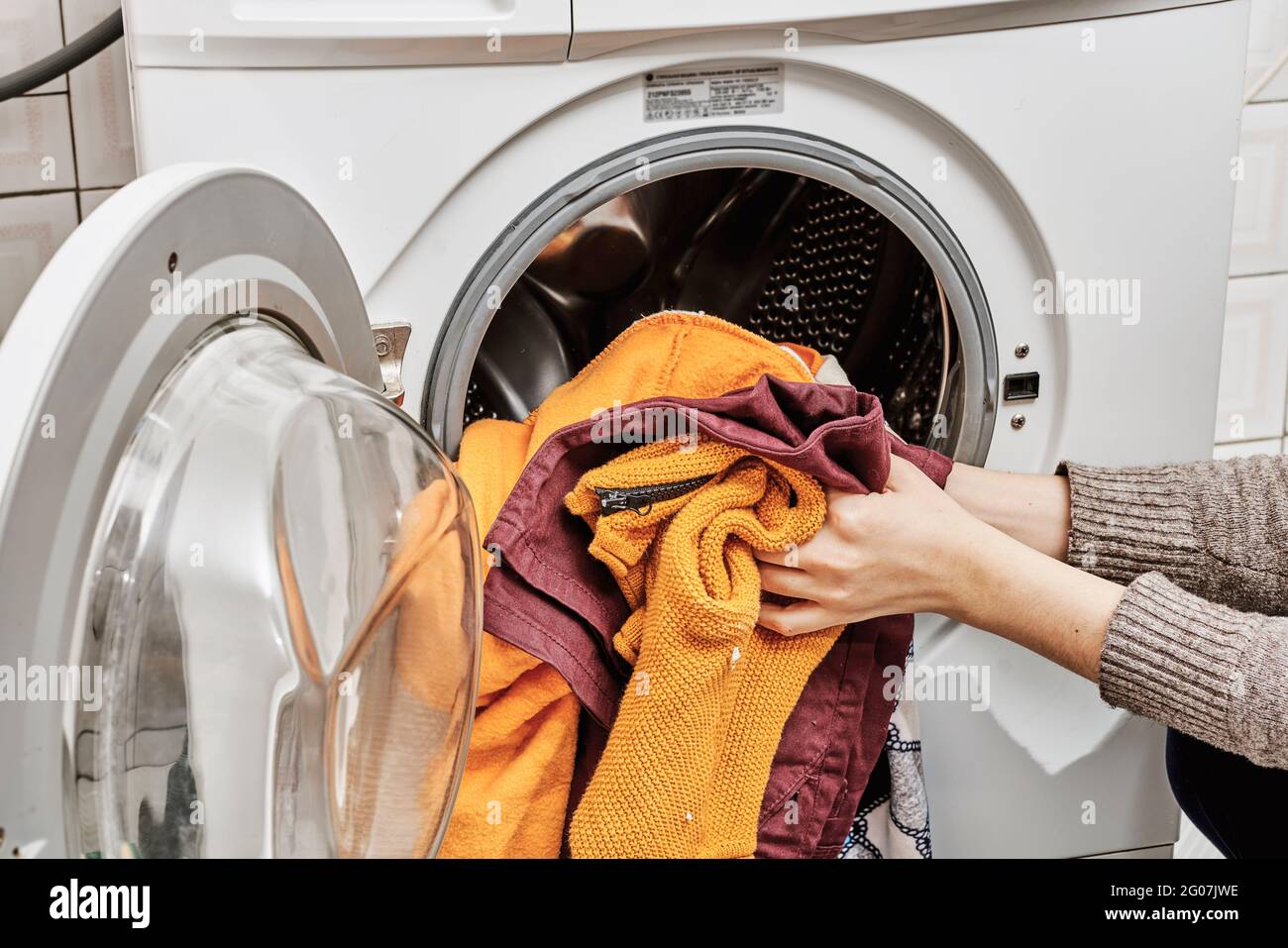 Mujer irreconocible lavando ropa sucia en la lavadora Fotografía de stock -  Alamy
