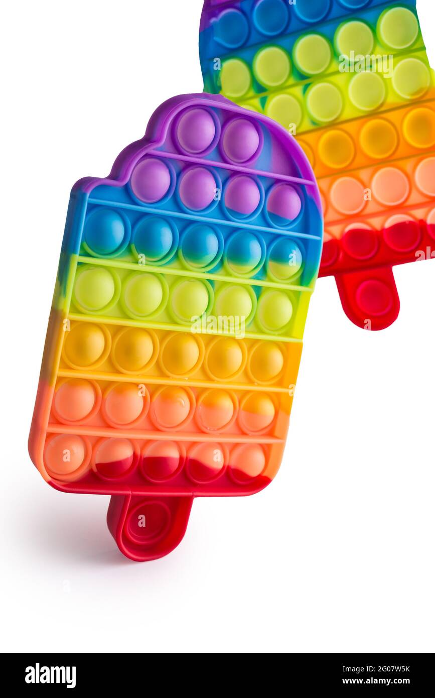 Pop it juguete antiestrés de silicona arco iris aislado sobre fondo blanco.  hoyuelos simples, populares y modernos juguetes para aliviar el estrés para  adultos y niños. juguete para niños fidget, pop bubble