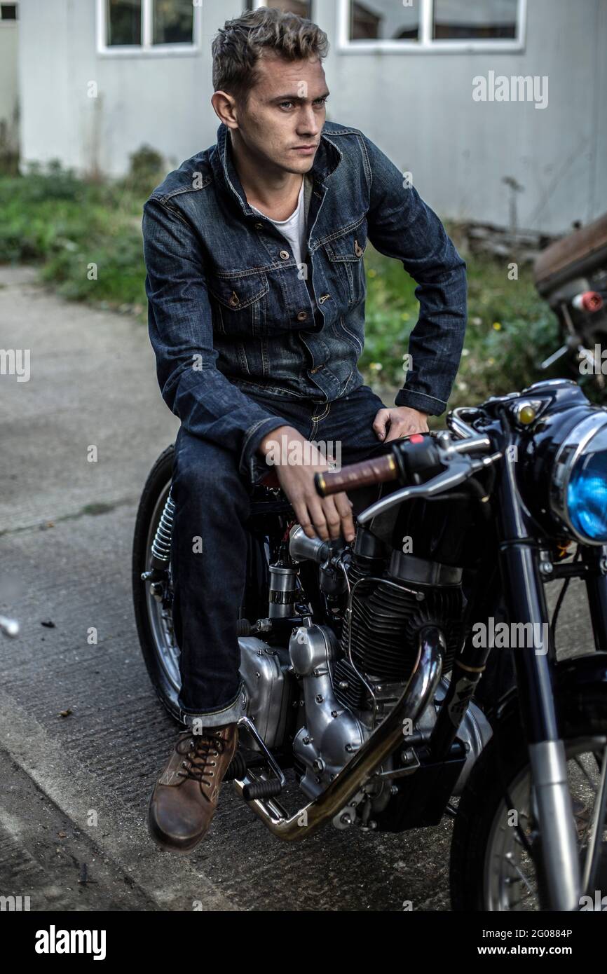 Imagen recortada del motociclista en jeans y botas de cuero con casco