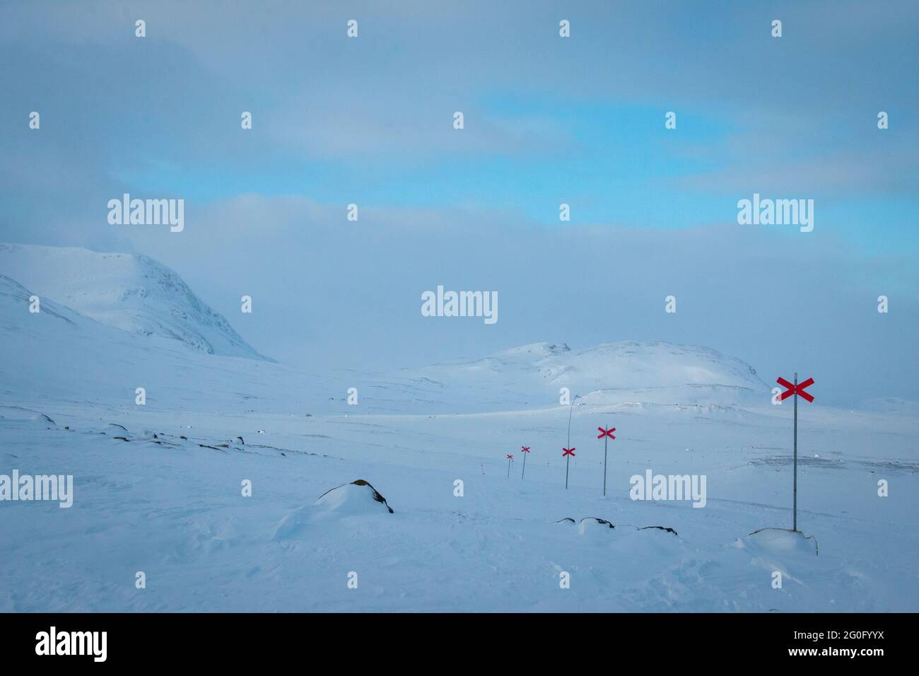 Saliendo de las cabañas de Alesjaure temprano por la mañana mientras se raquetas de nieve Kungsleden sendero, Laponia, Suecia 2021 de abril. Las cruces rojas marcan el camino. Foto de stock