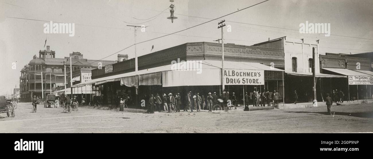 La concurrida esquina de Phoenix, Arizona - Postcard muestra una intersección de una calle en Phoenix, Arizona con hombres de pie frente a A.L. Farmacia Boehmer's. Los hombres están en bicicletas y una sola figura femenina está al lado de la calle con un trípode, 1907 Foto de stock