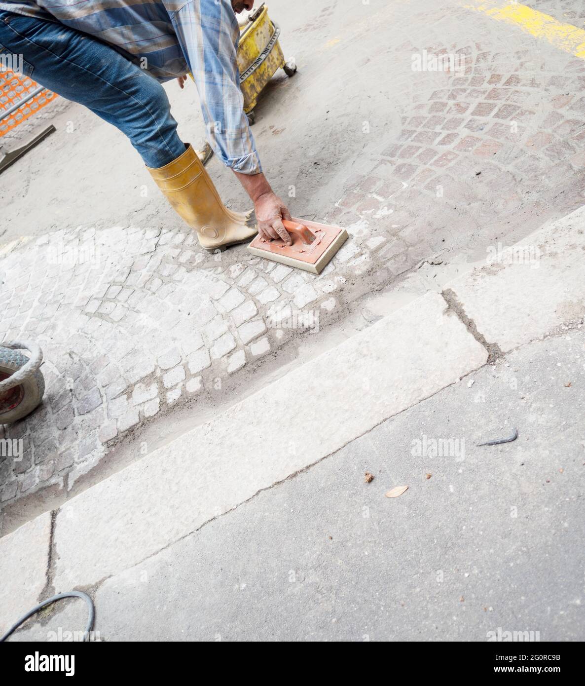 refabricación de la superficie de la carretera, colocación manual de cubos de pórfidos en la ciudad Foto de stock