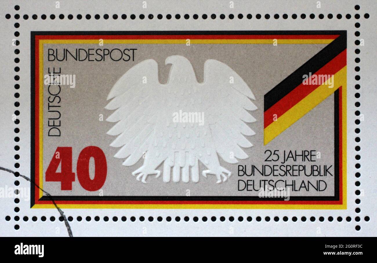 Un sello impreso en Alemania muestra el águila federal y la bandera, 25 años República Federal de Alemania, alrededor de 1974 Foto de stock
