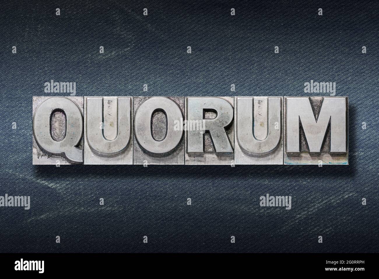 palabra de quórum hecha de tipografía metálica sobre fondo vaquero oscuro Foto de stock