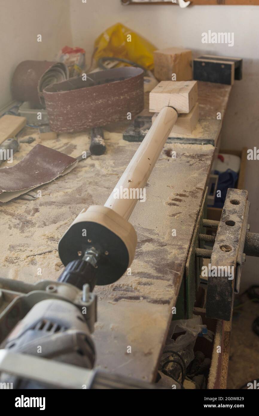 Hacer la pata de un taburete de madera en un taller de carpintería  utilizando un torno casero con un taladro electrónico sobre un banco de  trabajo Fotografía de stock - Alamy