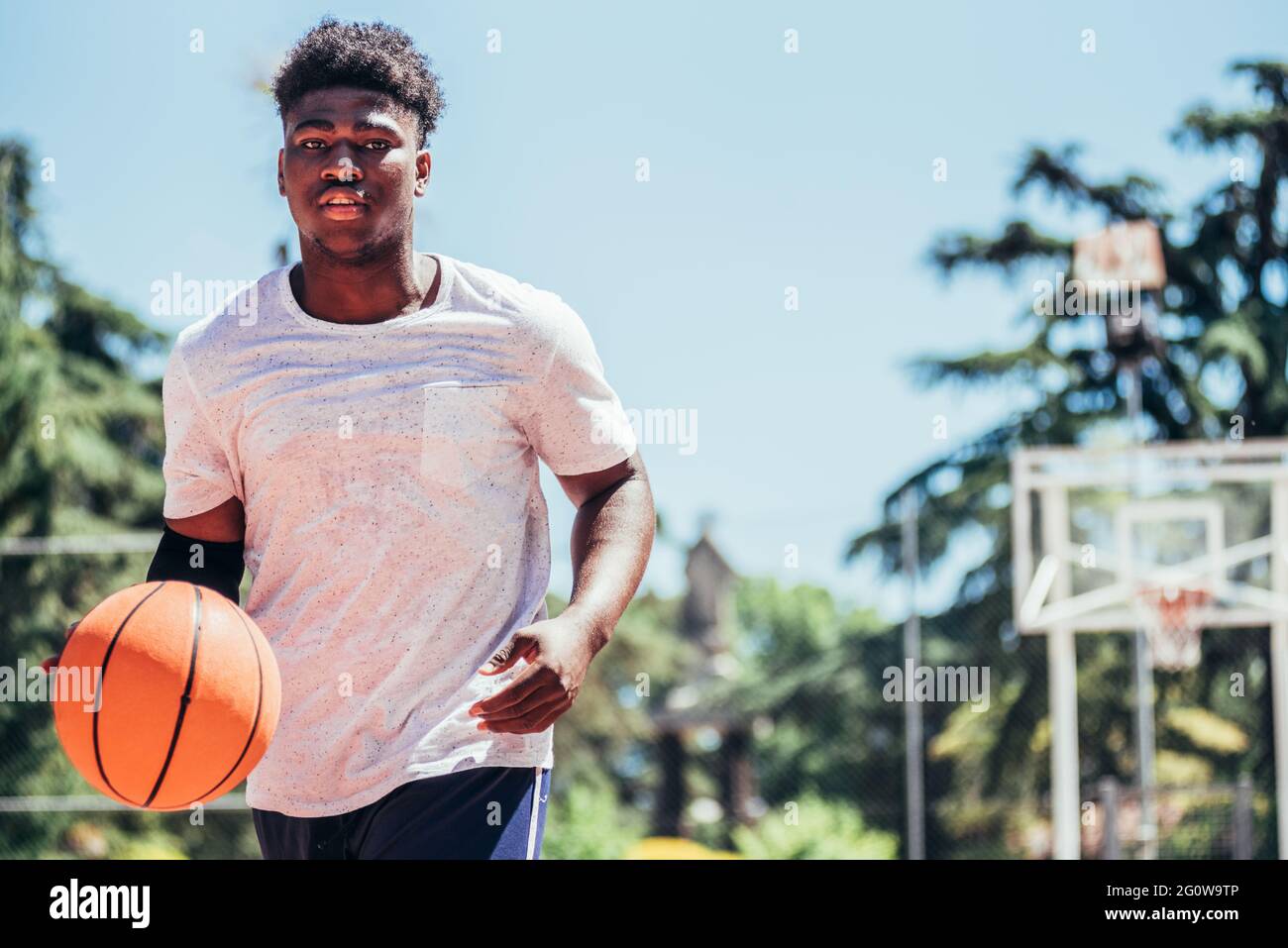 Retrato de un niño negro afroamericano jugando al baloncesto en una cancha  urbana. Correr y votar el balón Fotografía de stock - Alamy