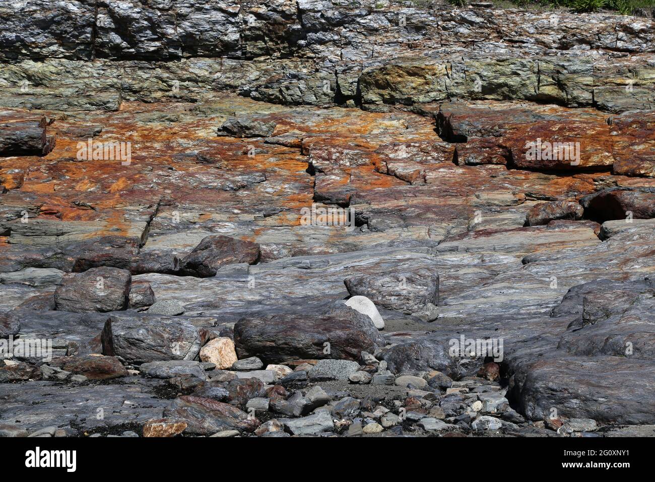 Acantilado costero del noreste del lado del océano de depósitos de roca sedimentaria metamórfica y en capas Foto de stock