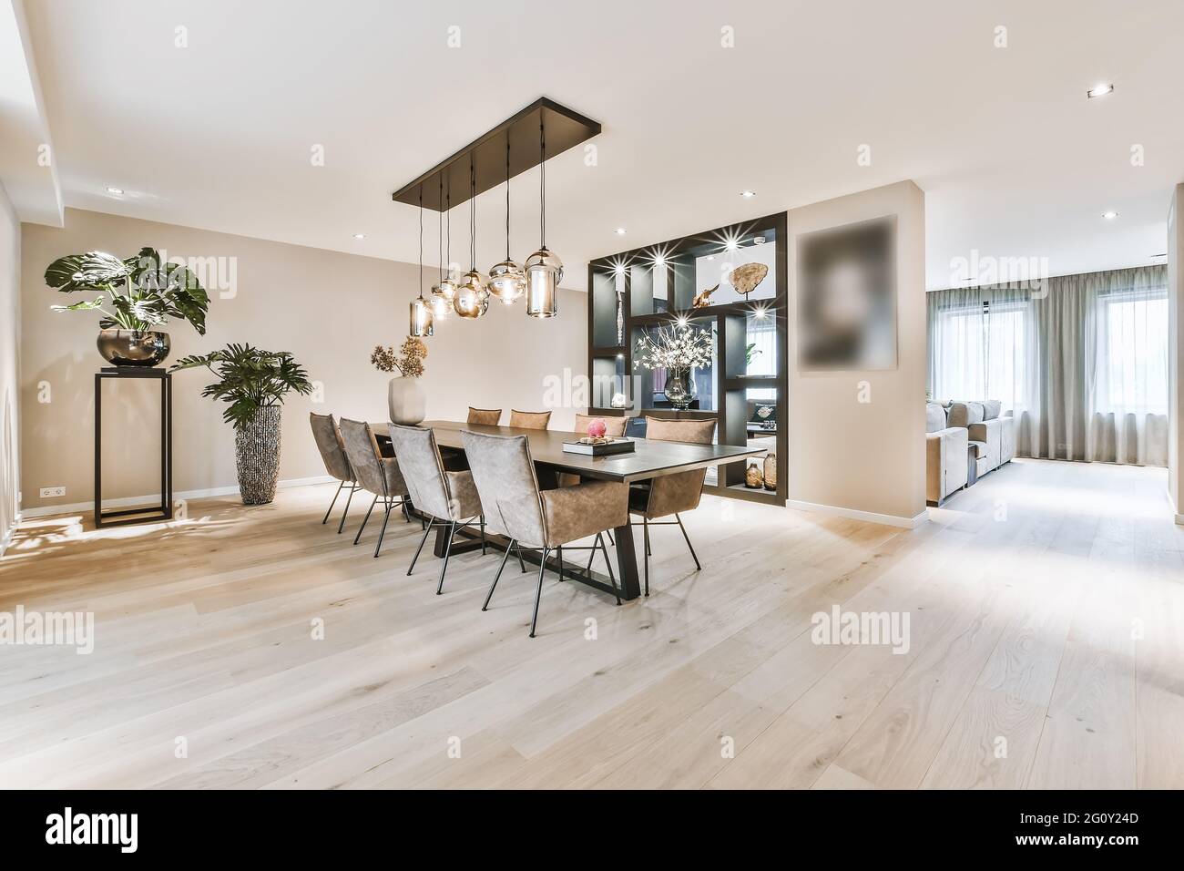 Amplio comedor de estilo minimalista con mesa y sillas apartamento moderno  con suelo de madera Fotografía de stock - Alamy