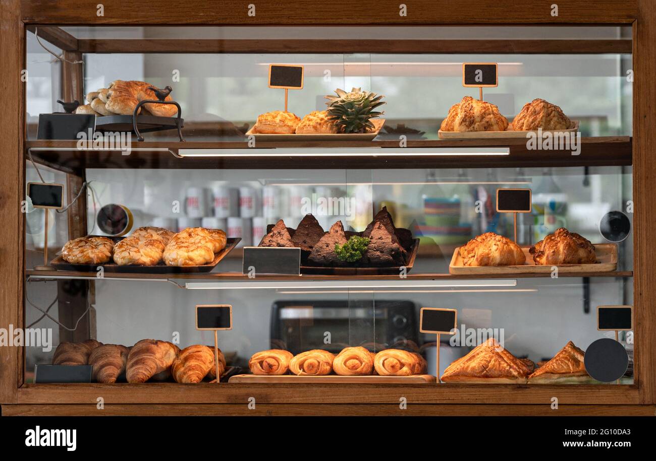 Variedad de pan horneado y postre en vitrinas de vidrio en la cafetería de  panadería Fotografía de stock - Alamy