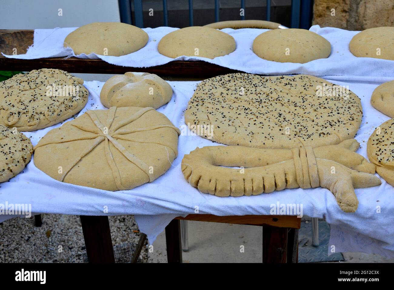 Una selección de panes chipriotas tradicionales hechos a mano listos para hornear en el horno de piedra Foto de stock