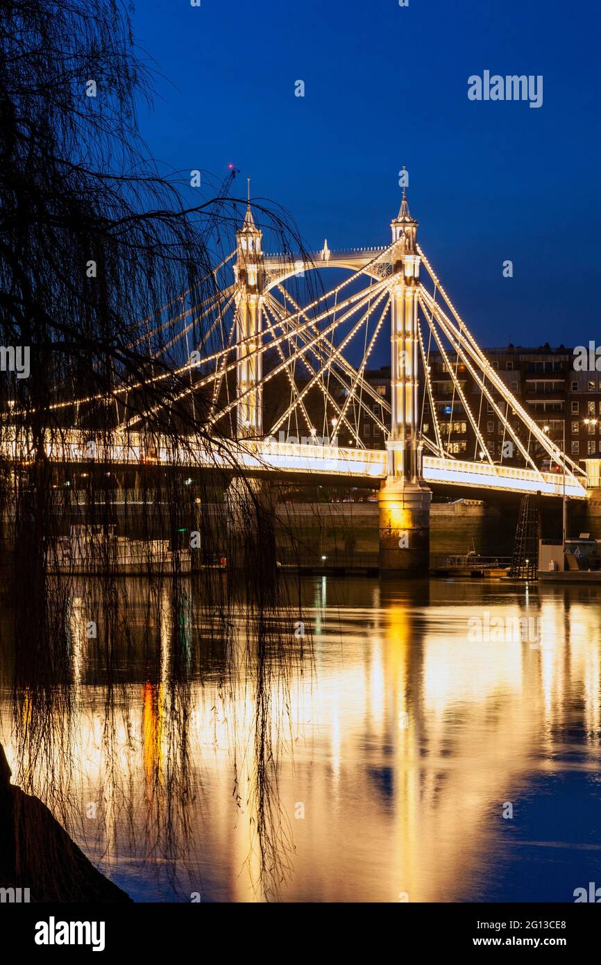 Reino Unido, Inglaterra, Londres, Battersea, Puente Albert al otro lado del río Támesis por la noche con árboles. Foto de stock