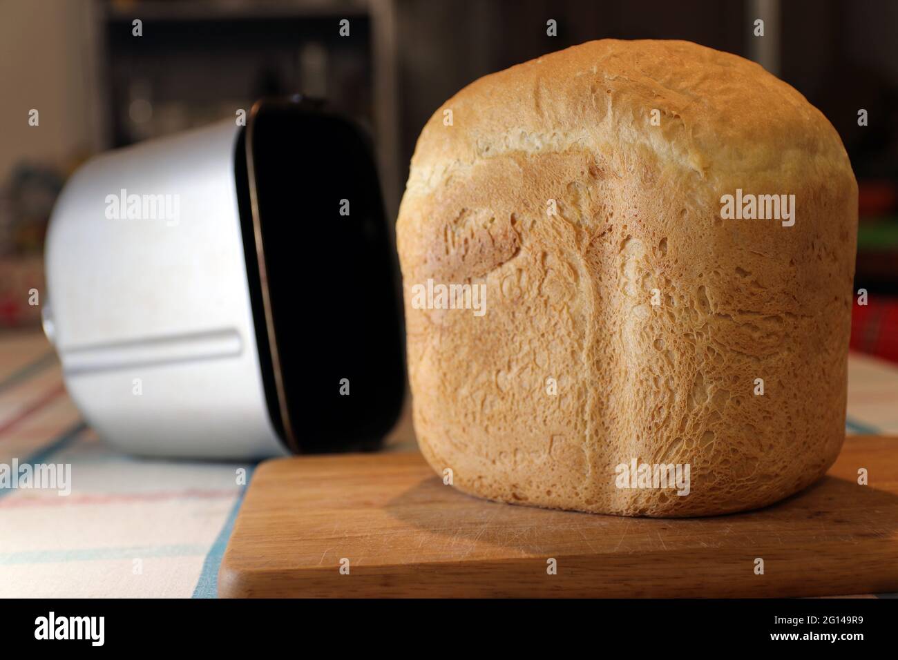 Pan horneado en máquina de pan en tabla de pan. Enfoque selectivo. Foto de stock