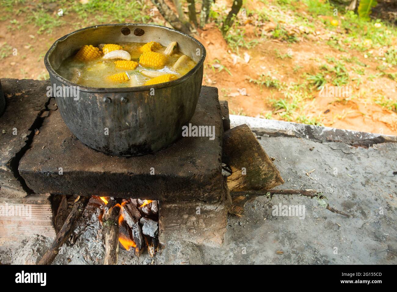 Plato típico colombiano de sancocho sobre estufa de madera Foto de stock