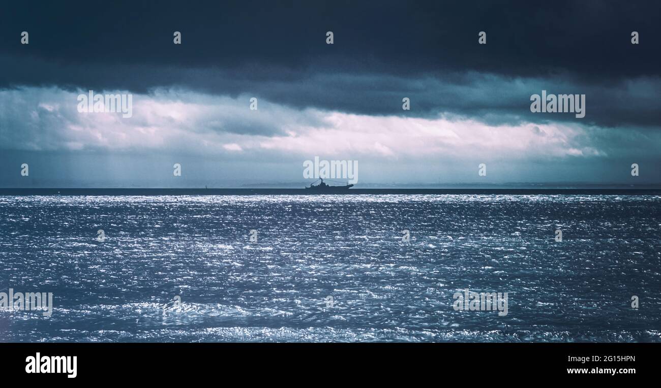 Dramatisches Foto an der Küste bei Regenschauer auf der Halbinsel Hel bei Sturm. Isla Hel Polonia mit Kriegschiff am Horizont Foto de stock