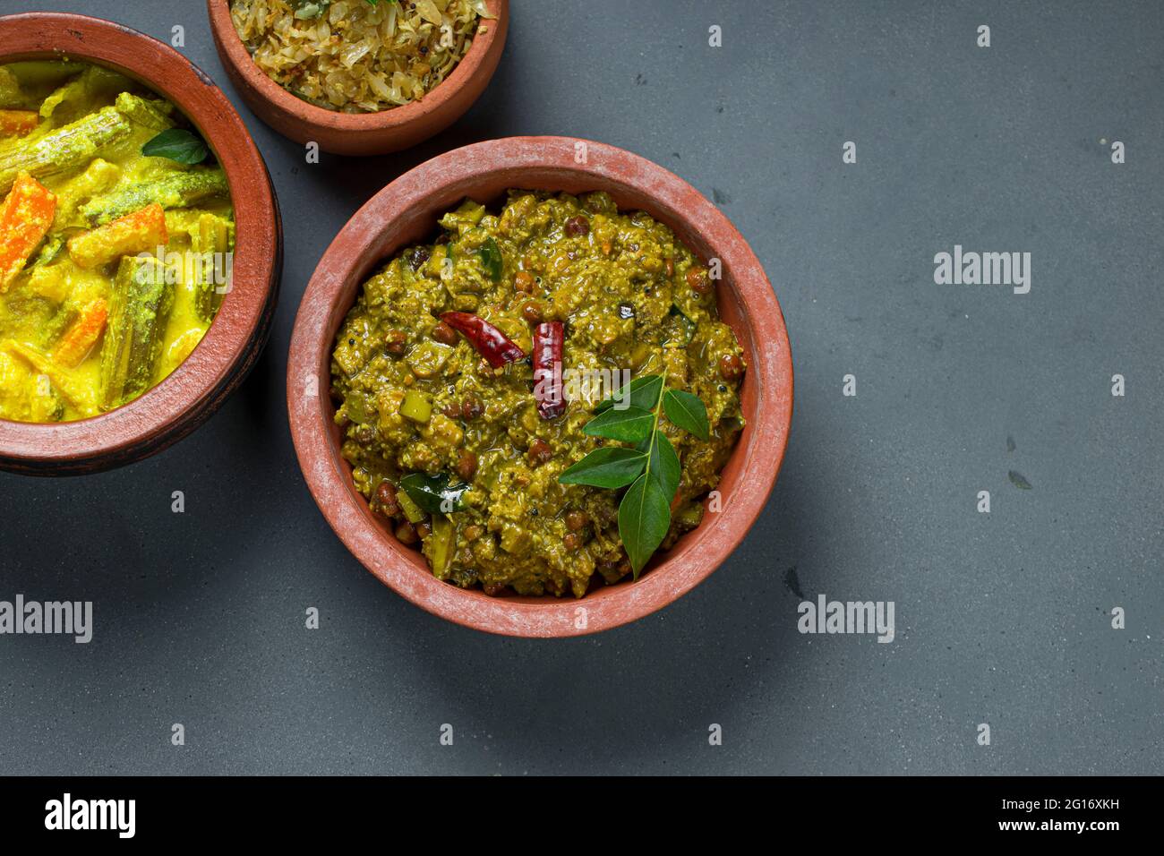 Avial, Kootu curry y y fritura de col Kerala platos tradicionales de  acompañamiento que es muy saludable y sabrosos platos vegetarianos,  dispuestos en un ingenio de barro Fotografía de stock - Alamy