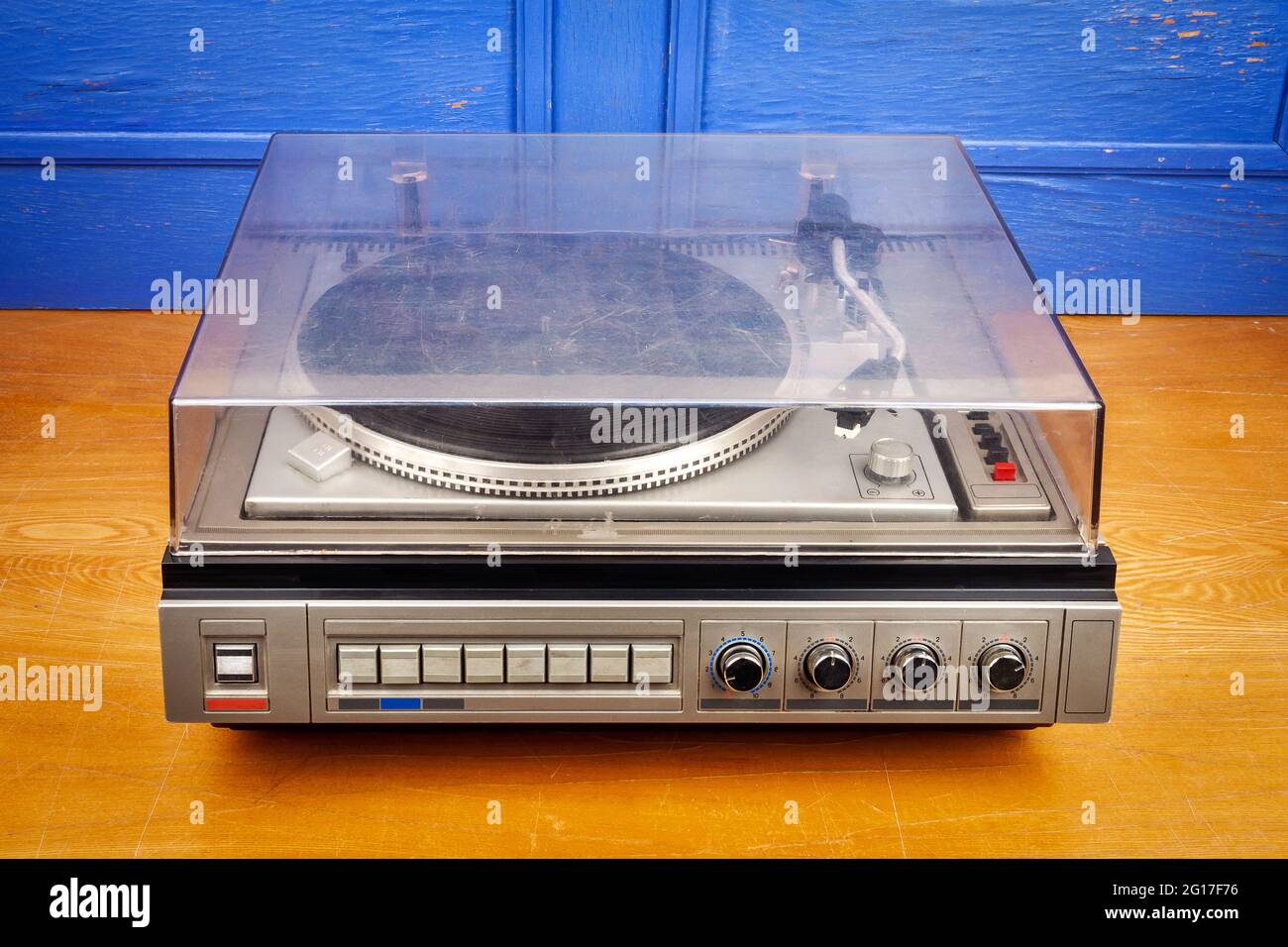 Vintage tocadiscos vinilo reproductor de discos con cubierta de polvo en la  mesa junto a la pared azul Fotografía de stock - Alamy