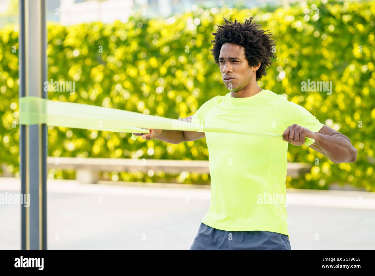 Hombre negro haciendo ejercicio con banda elástica al aire libre Foto de stock